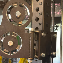 Load image into Gallery viewer, Close-up of a weightlifting machine with pulleys and weight stack in a gym setting.